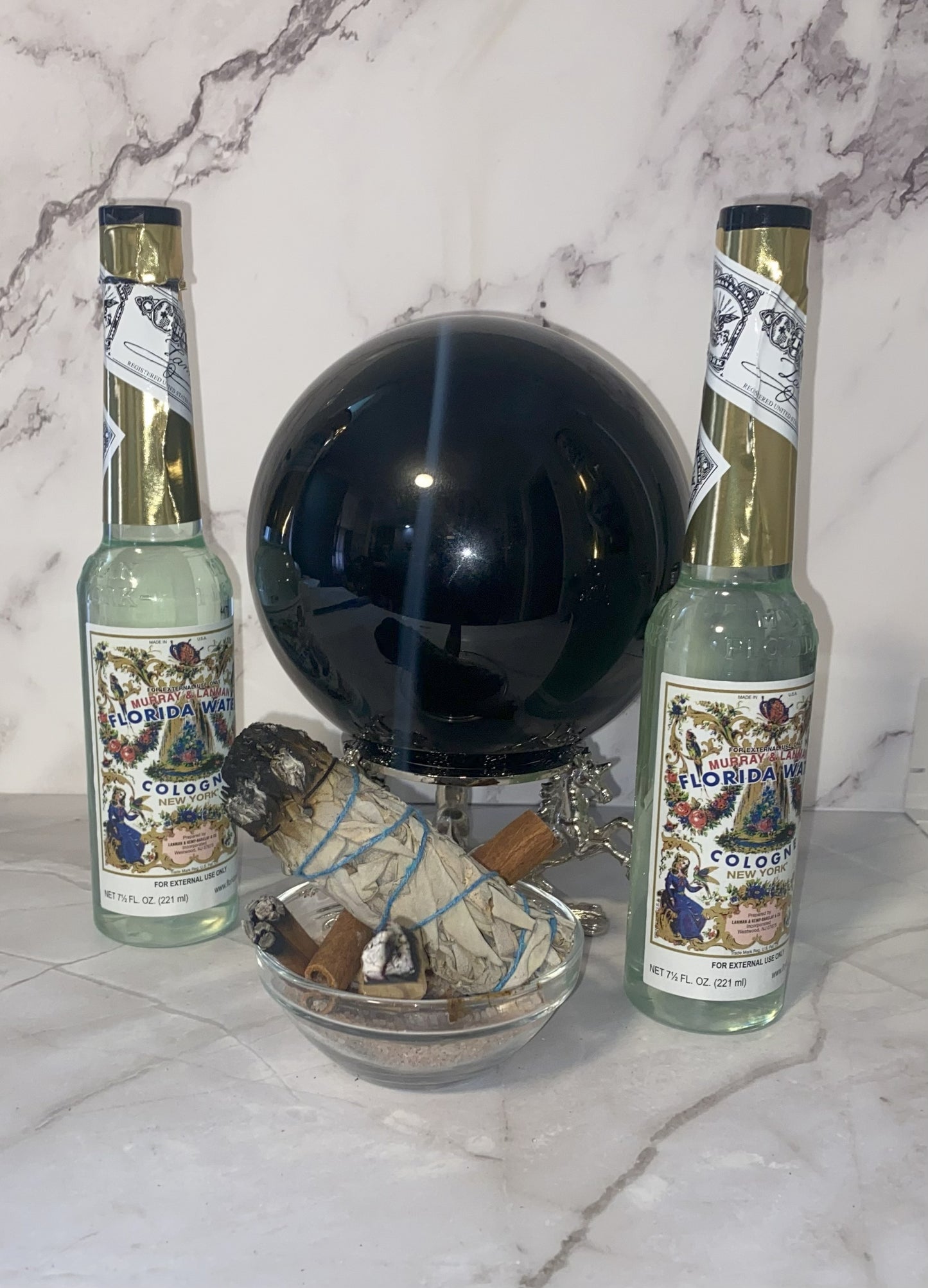 Two bottles of 'Florida' rum with a decorative sphere and small figurines on a marble surface.