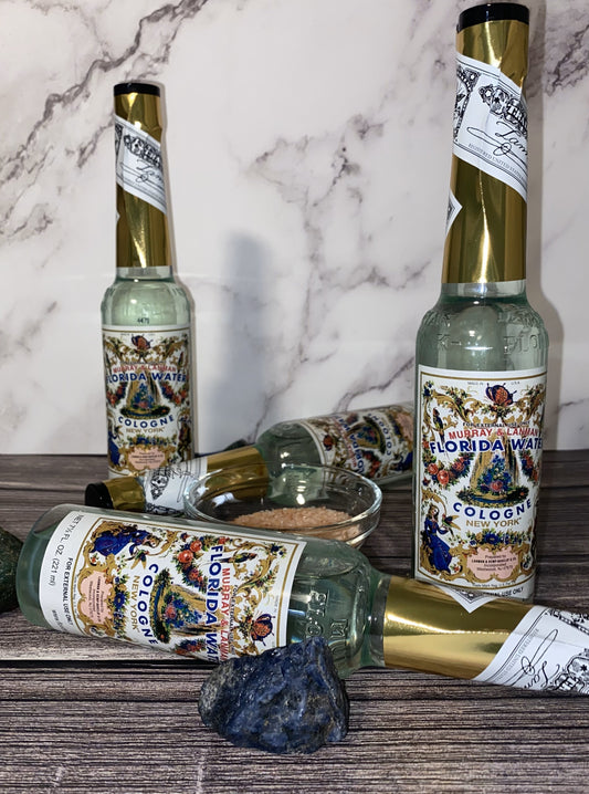 Bottle of Murray & Lanman Florida Water cologne with decorative labeling, displayed alongside a small container and a crystal.