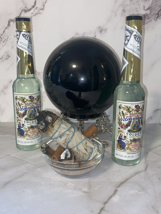 Two bottles of Old Florida cologne with a black globe and decorative items on a marble surface.